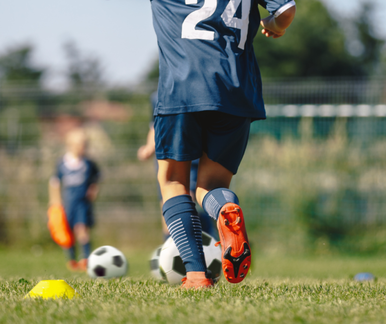 child playing soccer on field